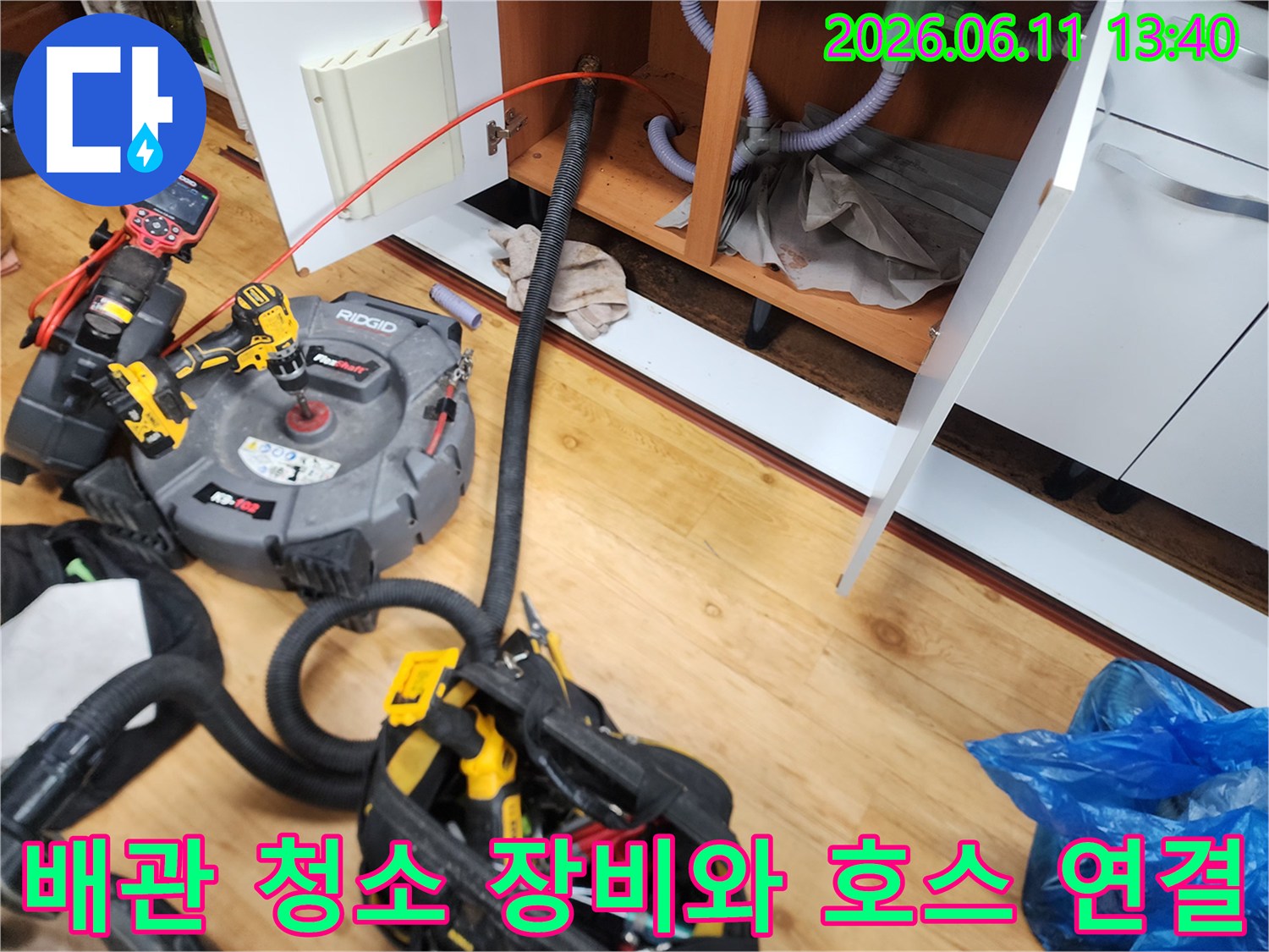 싱크대 하부 배관에 연결되어 작동 중인 배관 청소용 흡입 장비입니다.