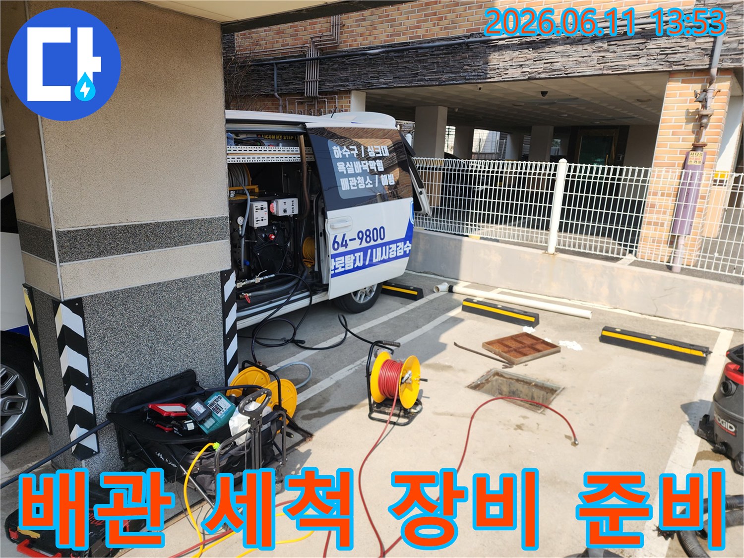 고압세차용 호스 릴과-배관 청소용 압력 장비가 차량 옆에 배치되어 있습니다.