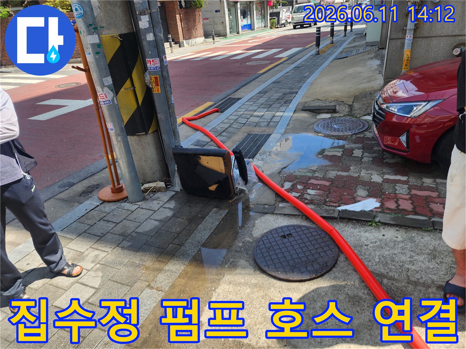 도로 맨홀 옆으로 설치된 배수용 붉은색 호스 전경