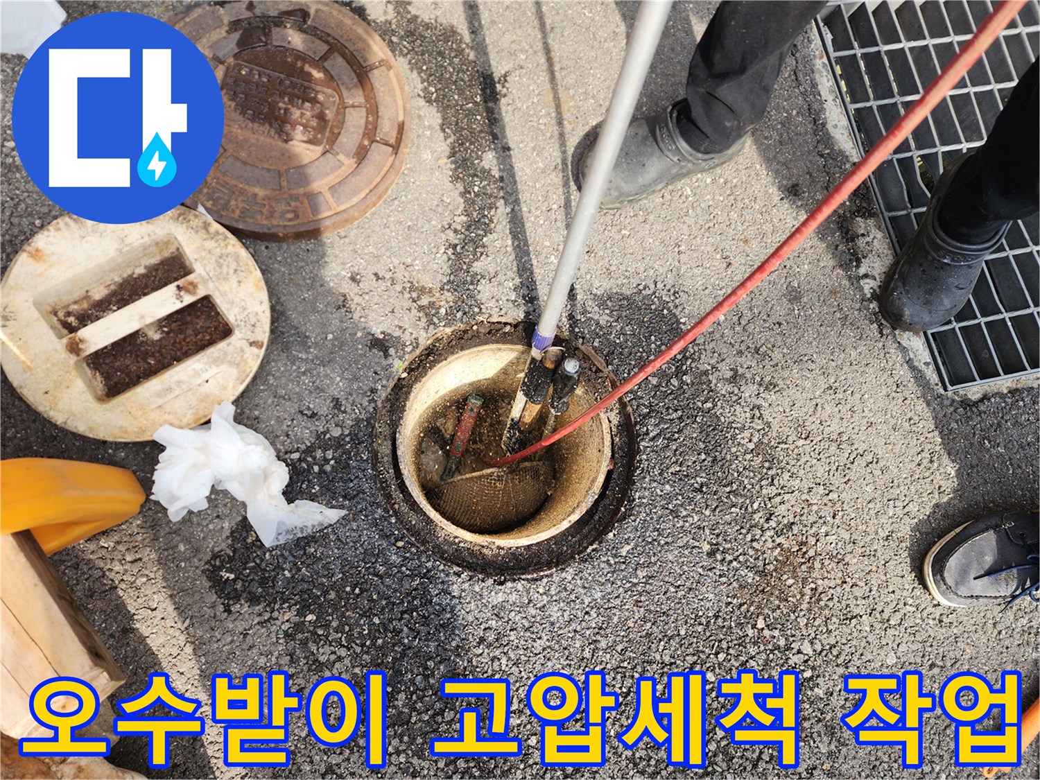 공용 오수받이 내부로 고압 세척 호스를 투입하여 슬러지를 제거하는 모습