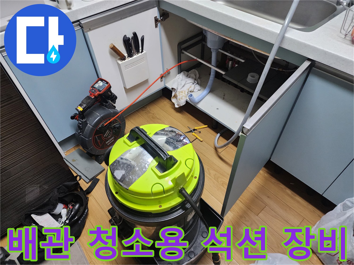 싱크대 아래쪽 공간에서 진행되는 배관 세척 작업 모습
