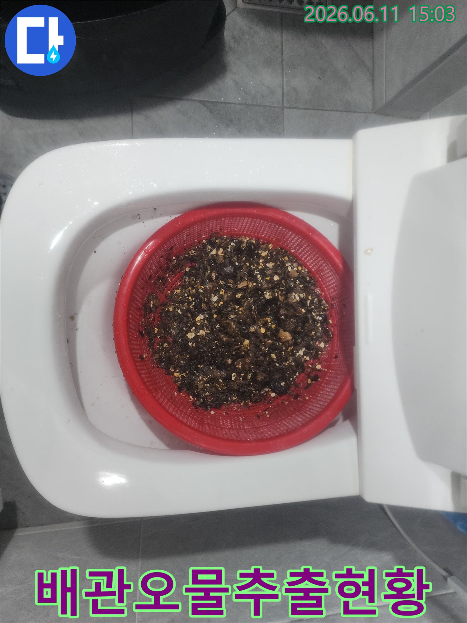 채반에 모인 배관에서 나온 검은색 기름 덩어리 슬러지