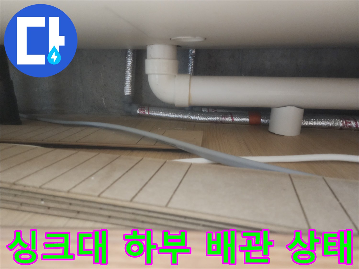 구리 갈매동 싱크대 아래쪽의 흰색 PVC 배수관과 은색 자재 연결 부위 모습