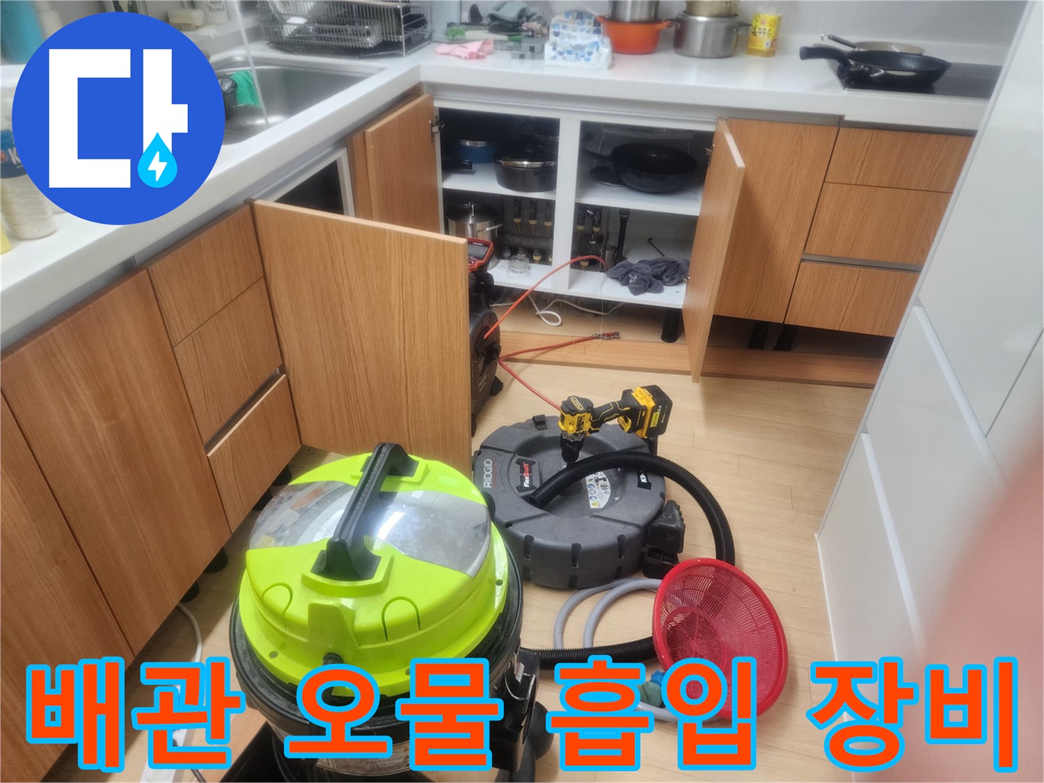 주방 바닥에서 진행 중인 배관 세척용 진공 흡입기와 필터 망