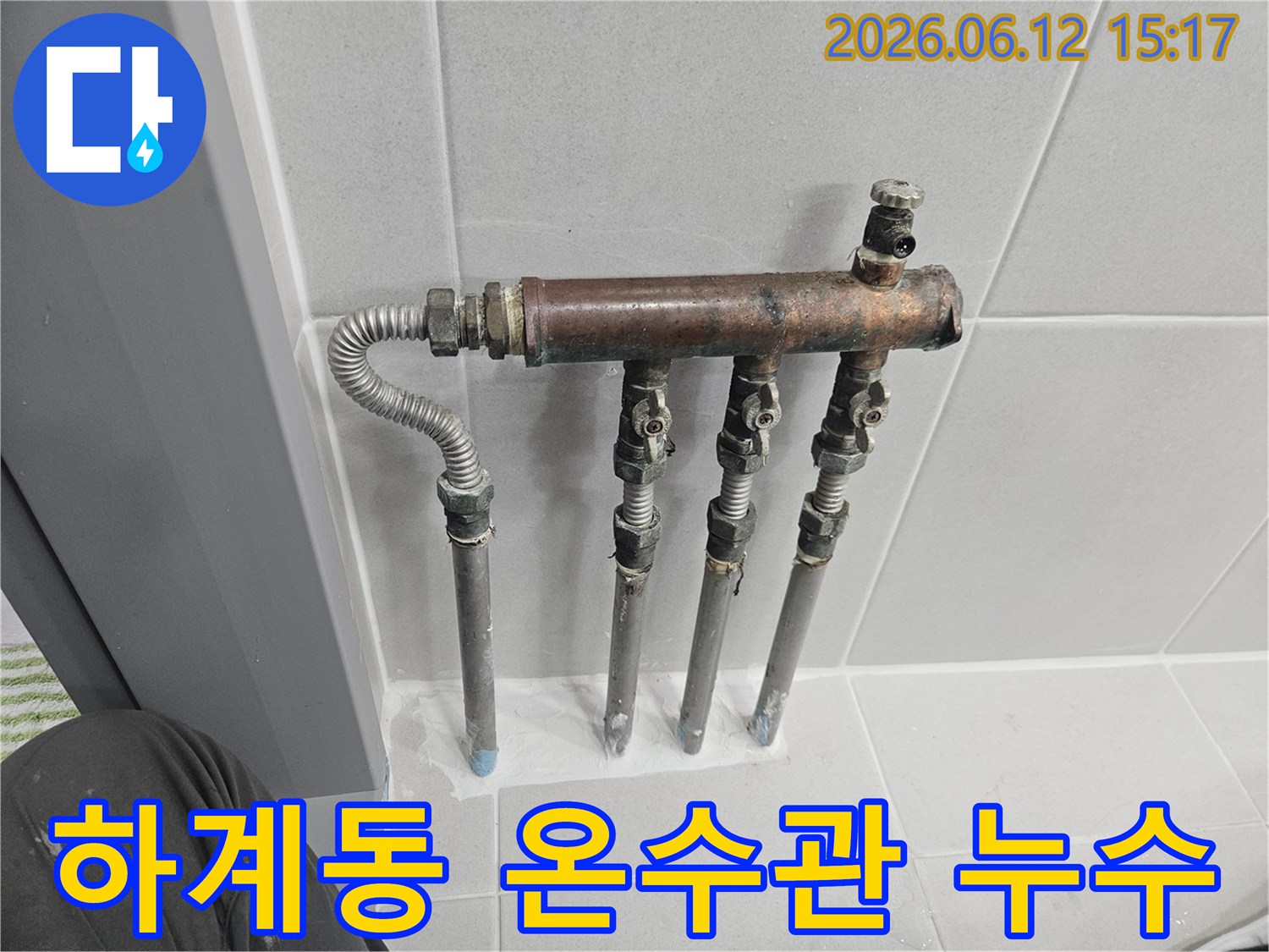 하계동 아파트의 온수 배관 분배기에서 누수 징후가 포착되어-전문가가 노후된 배관과 밸브 상태를 꼼꼼히 확인하고 있습니다