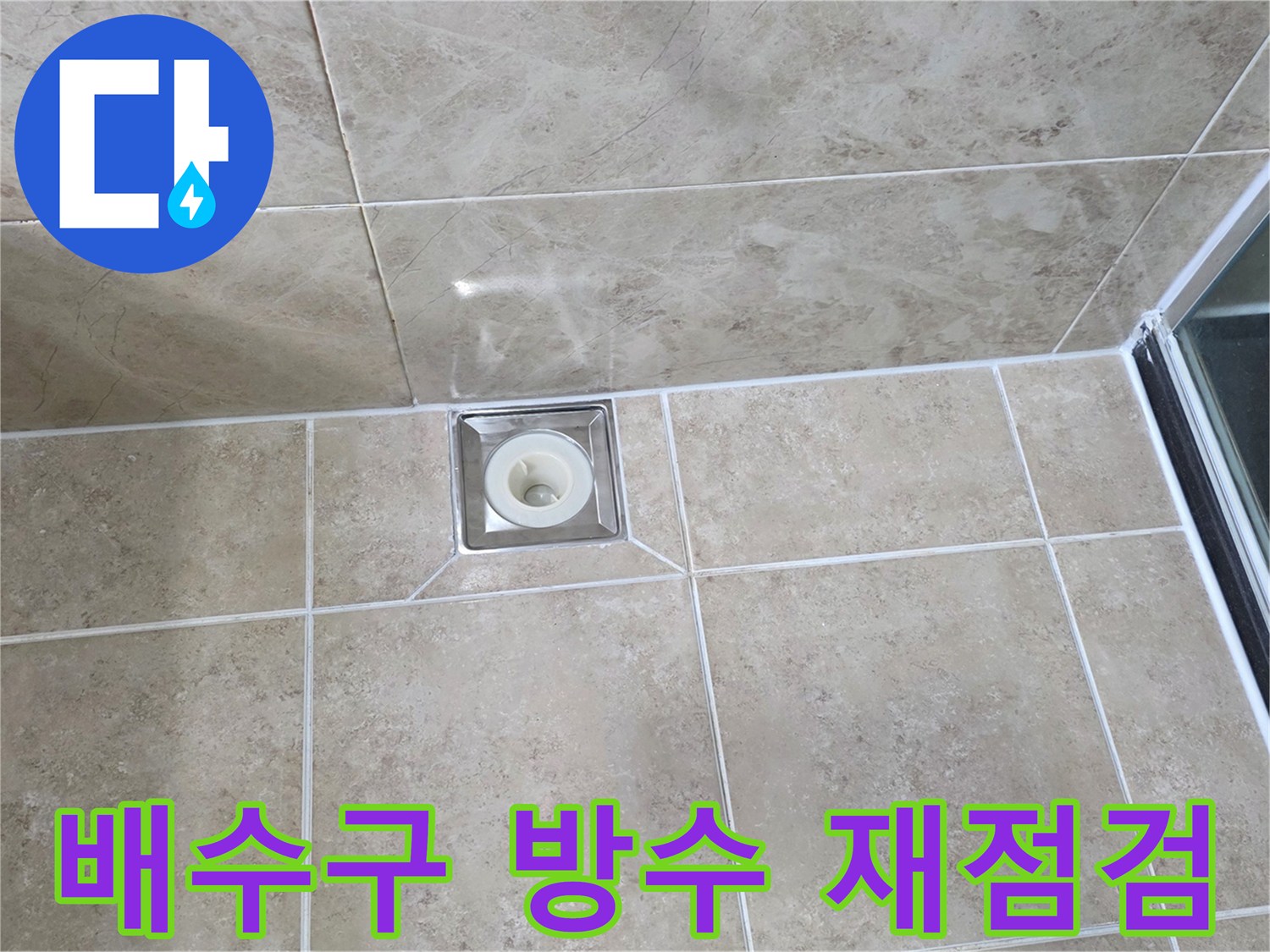 베이지색 타일 바닥에 설치된-금속 사각 배수구의 모습으로-주변 줄눈과 타일의 상태를 점검하는 이미지입니다