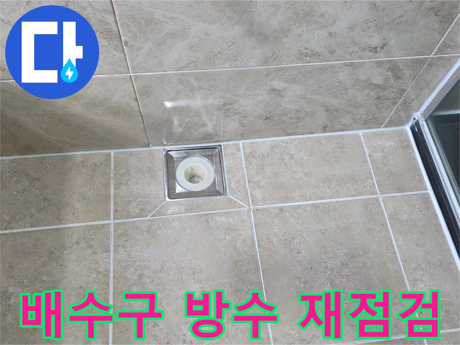 베이지색 타일 바닥에 설치된-금속 사각 배수구의 모습으로-주변 줄눈과 타일의 상태를 점검하는 이미지입니다