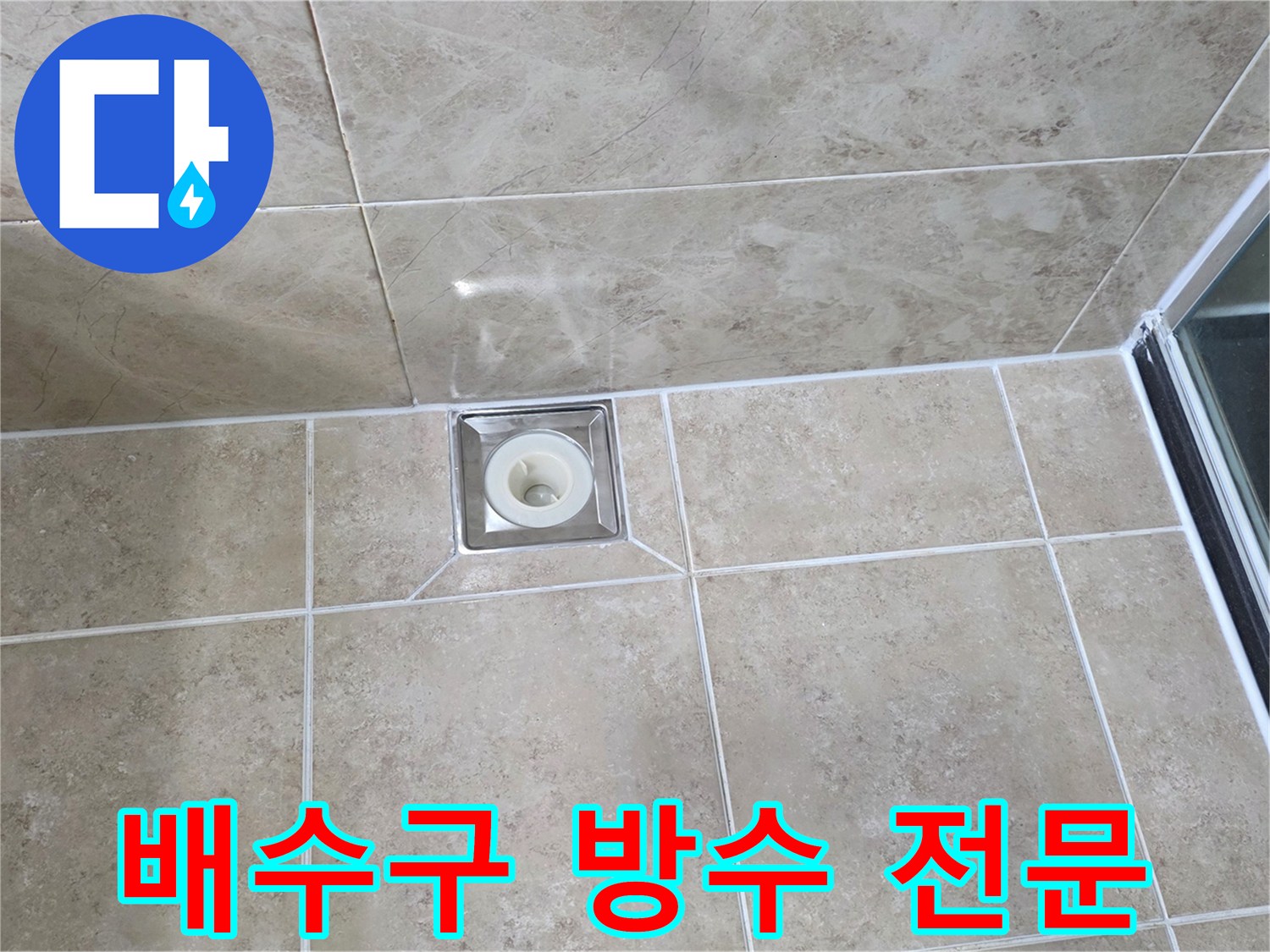 욕실 바닥의-베이지색 타일과-중앙에 위치한 금속 배수구의 모습으로-방수 상태를 점검하는 이미지입니다