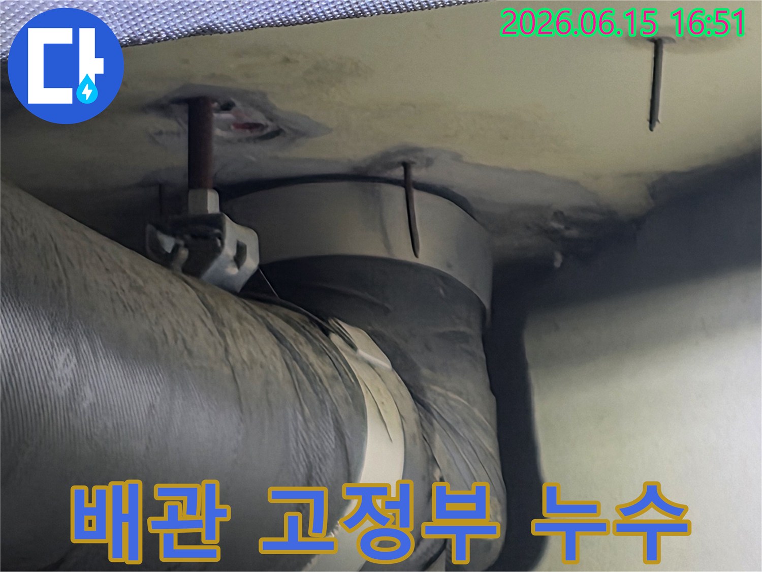 천장 배관 고정부 주변에 나타난 습기와 누수 흔적-이는 배관 연결부의 문제일 수 있습니다