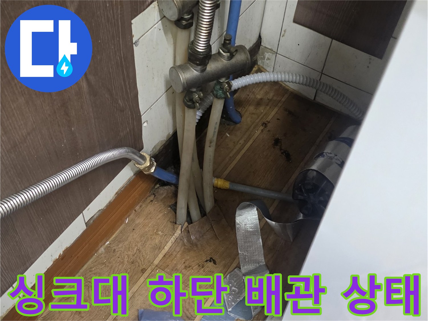 주방 싱크대 하부장 내부의 금속 주름관과 연결 부품 점검 과정