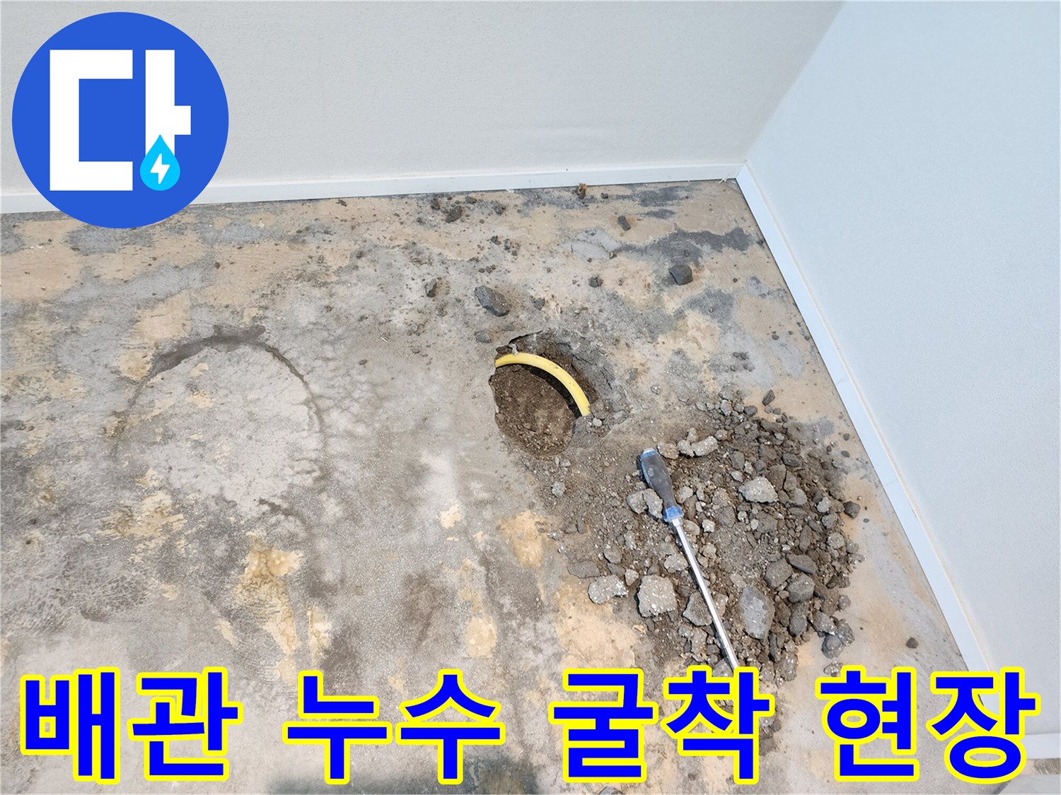 콘크리트 바닥을 뚫고 노출된 노란색 배관과 주변 작업 부위