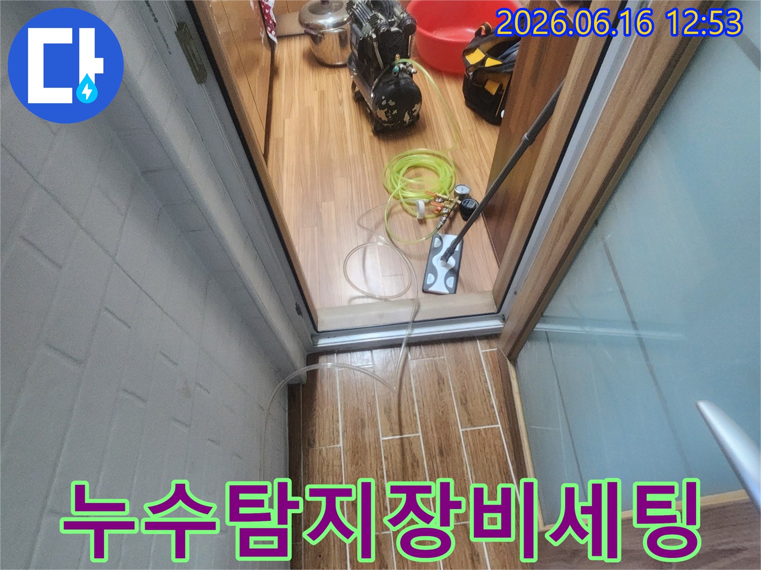누수 엔지니어가 아파트 내부에서 누수-탐지 장비를 세팅하며 작업 준비를 하고 있습니다.
