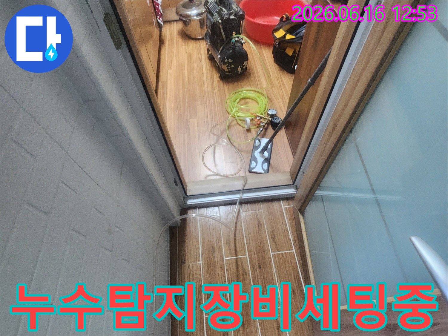 누수 엔지니어가 아파트 내부에서 누수-탐지 장비를 세팅하며 작업 준비를 하고 있습니다.