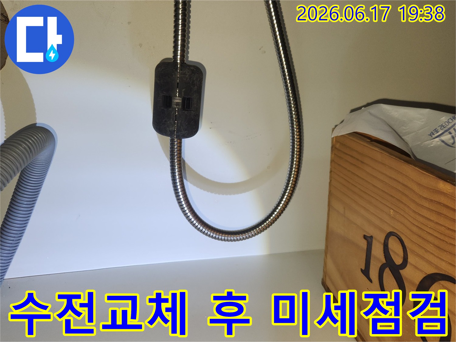 교체된 수전의 호스 연결 부위를-미세한 누수까지 확인하기 위해-집중적으로 점검하는 장면입니다