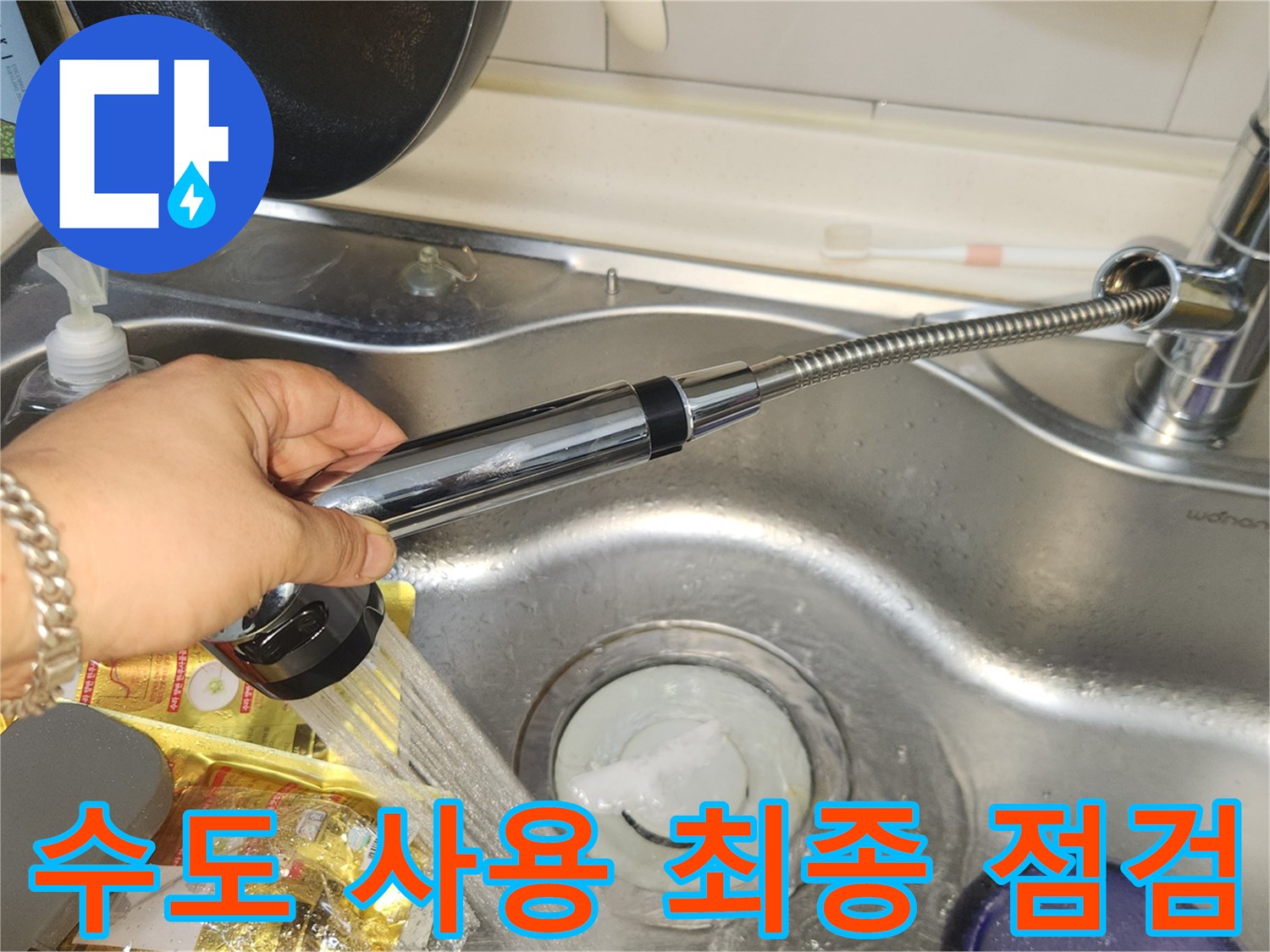 주방 배관 누수 공사 완료 후-싱크대 수도꼭지의 물 흐름과-배수구의 물 빠짐 상태를-최종적으로 점검하는 모습입니다.