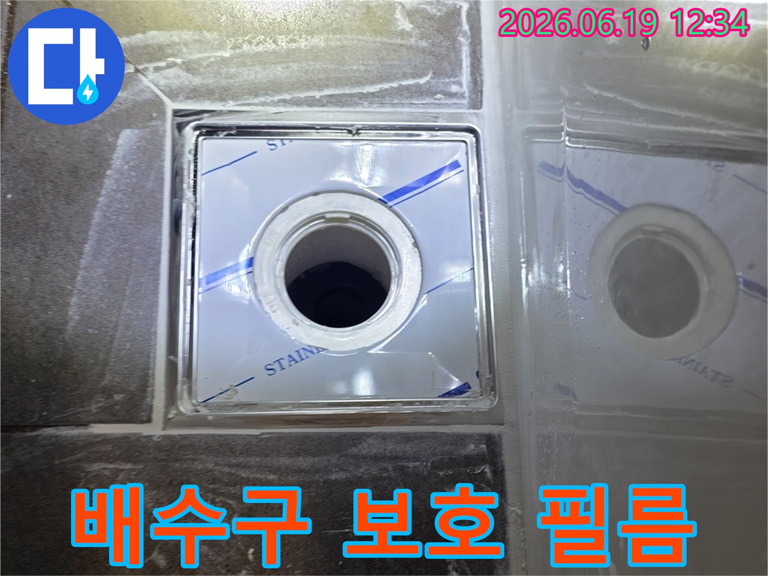 스테인리스 배수구 표면을 덮고 있는-파란색 보호 필름의 확대된 모습으로-시공 중 손상 방지 역할을 강조하는 사진