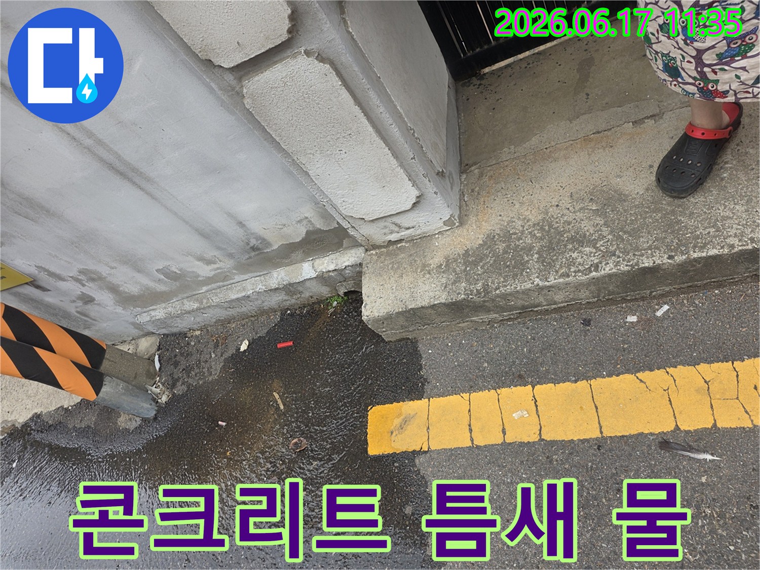 콘크리트-기초-아래에서-새어-나온-물이-도로-아스팔트-위에-고여있는-모습