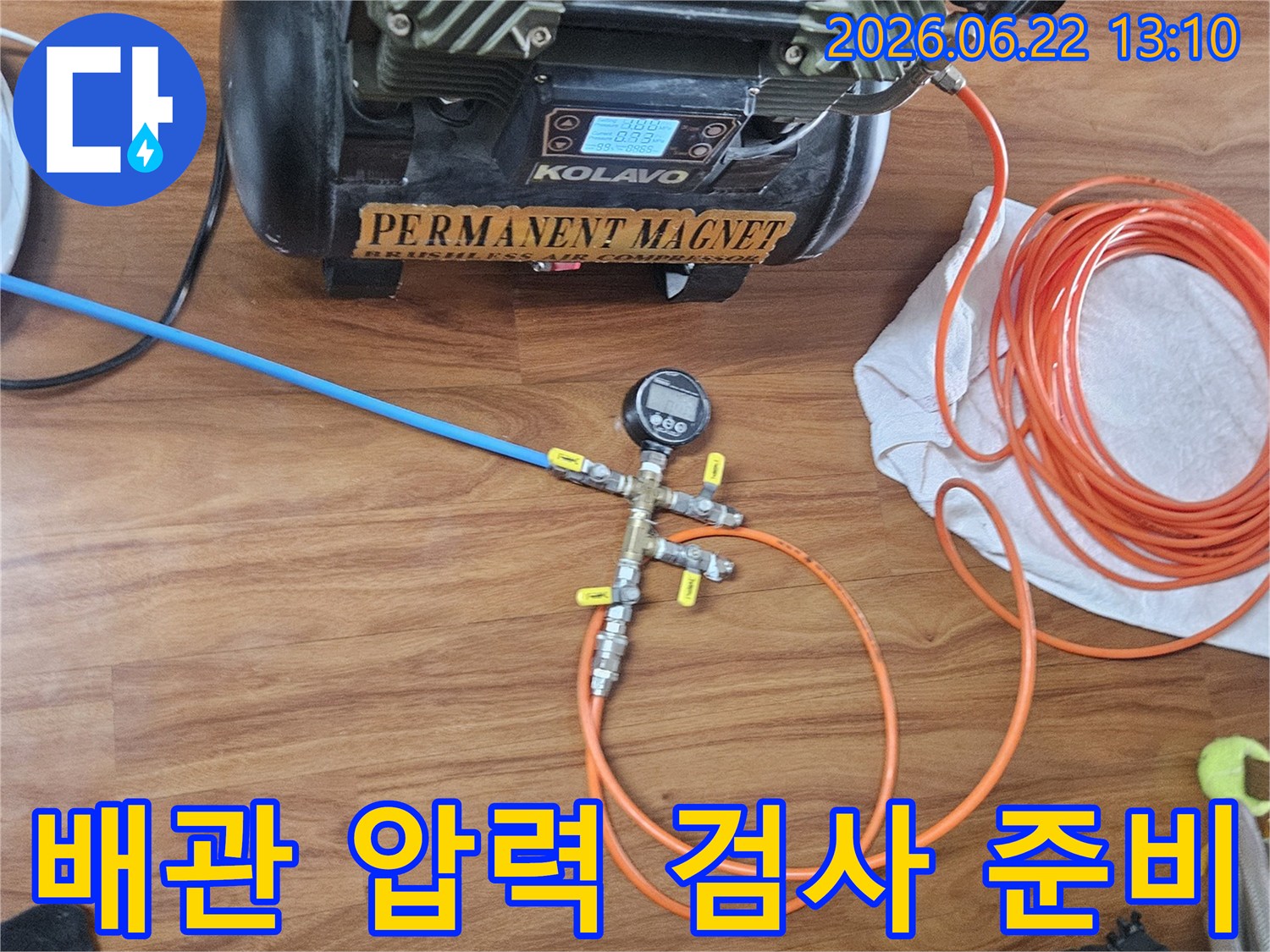 누수 탐지를 위해-압력 게이지와 공기 압축기를 배관 시스템에 연결하는 작업 현장입니다