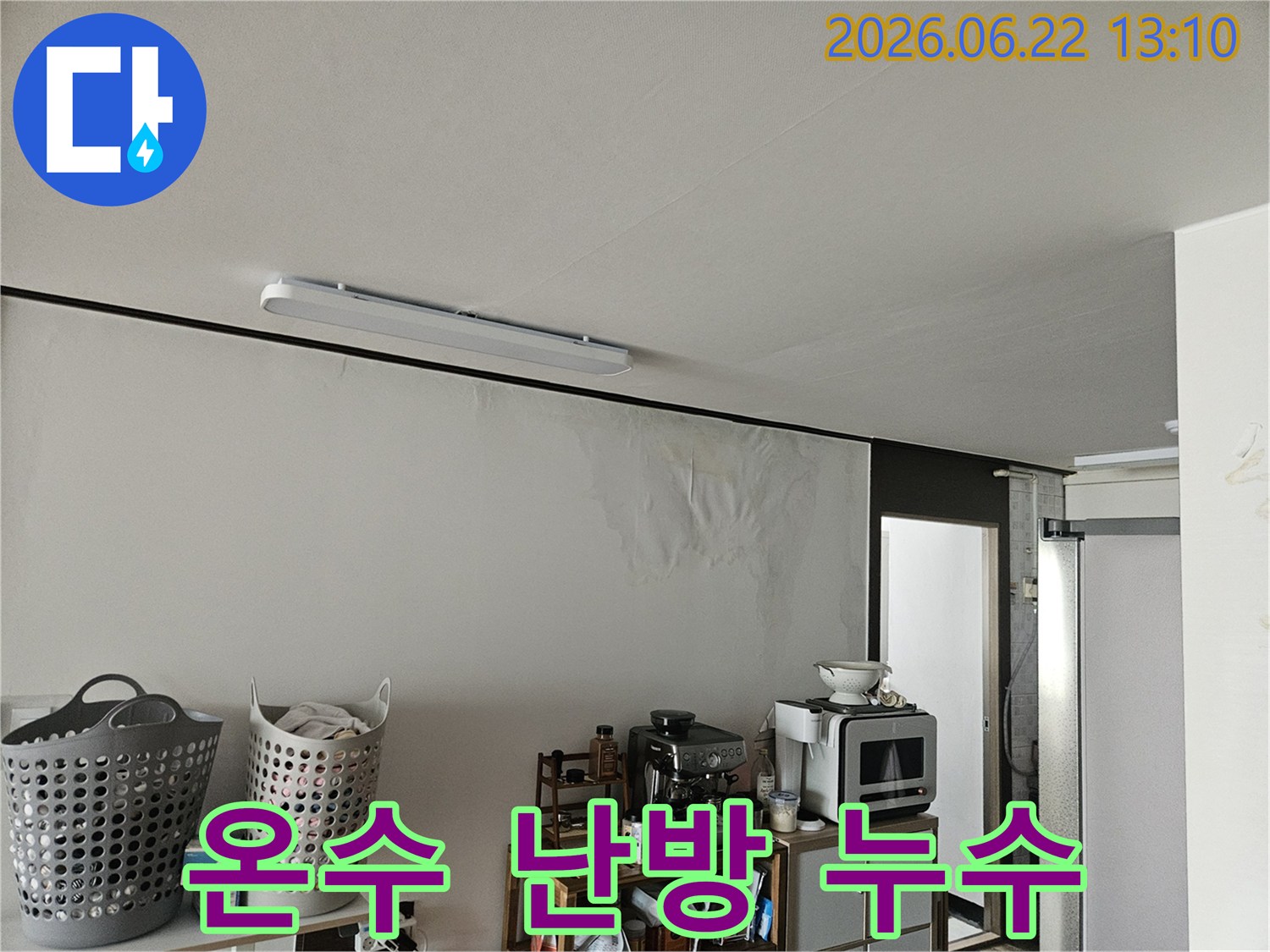 벽면의 넓은 부위가 누수로 인해 젖어있고-벽지가 울퉁불퉁하게 변형된 상태를 보여주는 주거 공간의 모습입니다.