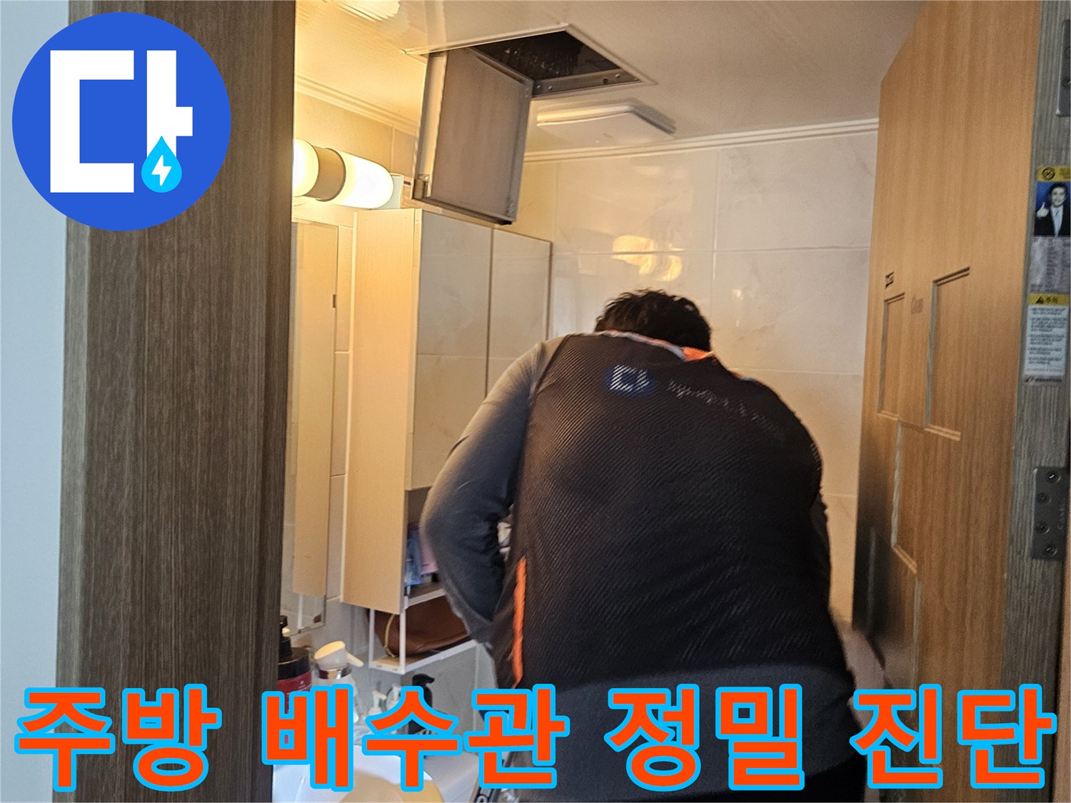 싱크대 하부장 내부의 배수구 상태를 면밀히 조사하는 작업 장면