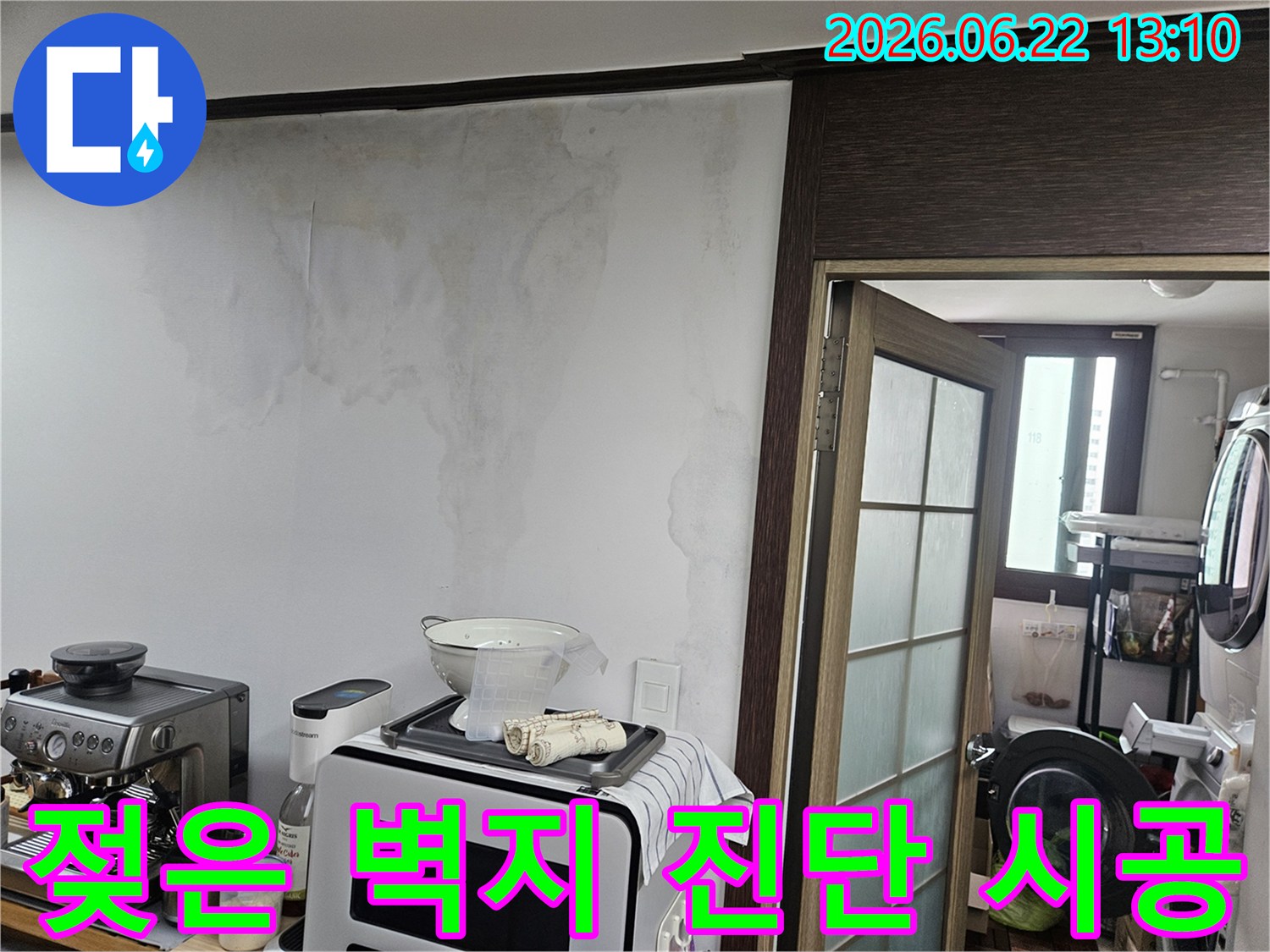 아파트 주방 벽면에 나타난-천장 누수로 인한-심각한 물자국과-벽지 손상 모습을 보여주는 사진