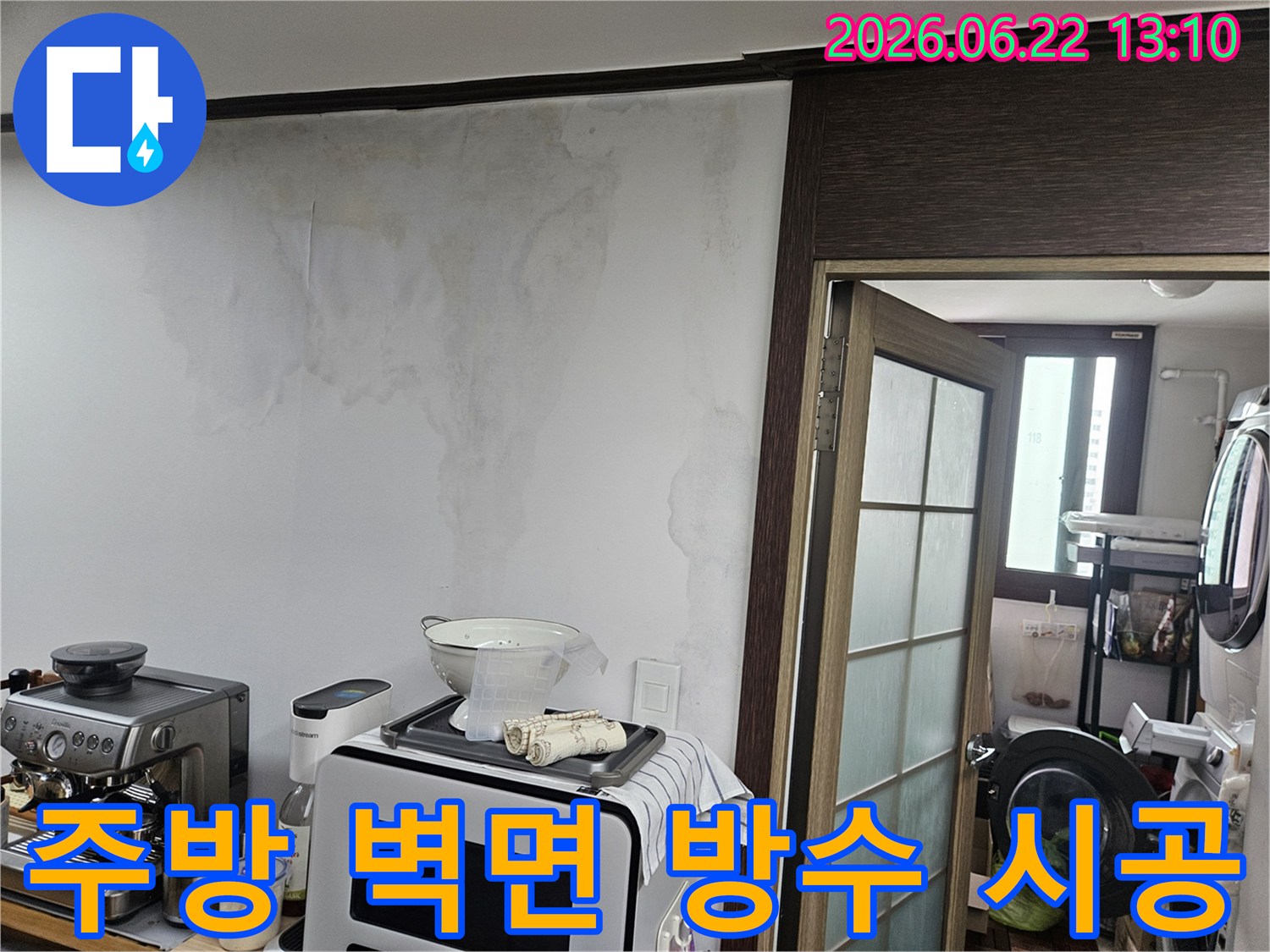 천장 누수로 인해-주방 벽면의 벽지가 젖고-얼룩이 생긴-아파트 내부의 손상된 벽 모습