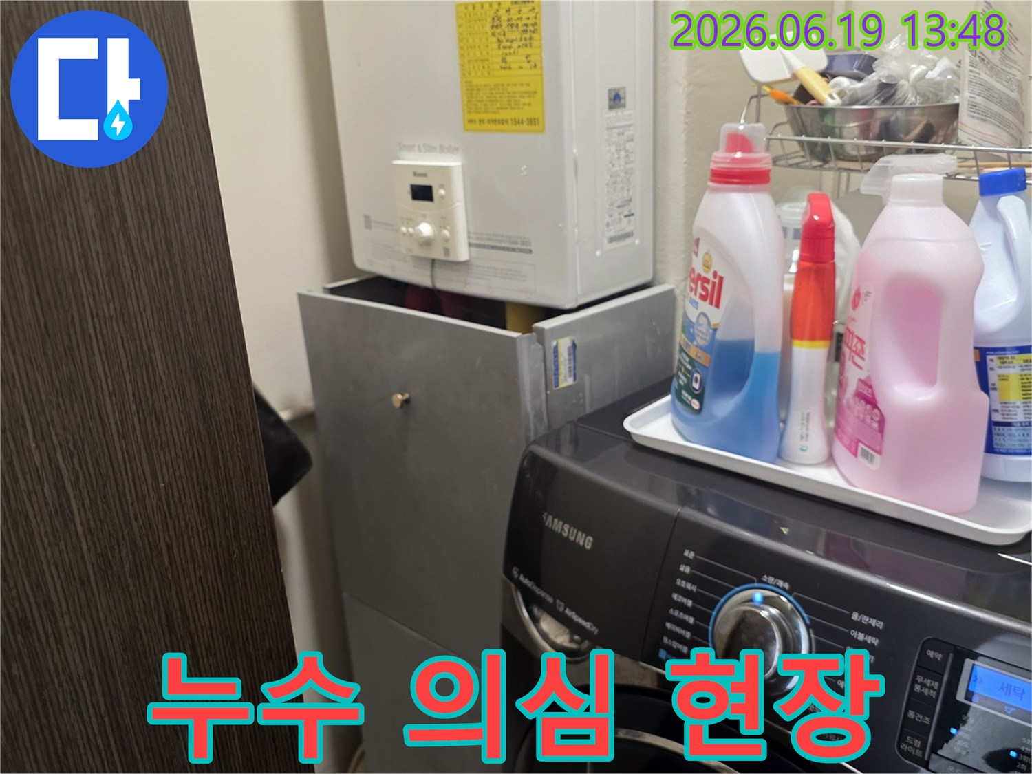 세탁실 바닥에서-발견된 누수 흔적을-확인하기 위해-보일러와 세탁기-주변을-점검하는-사진입니다.