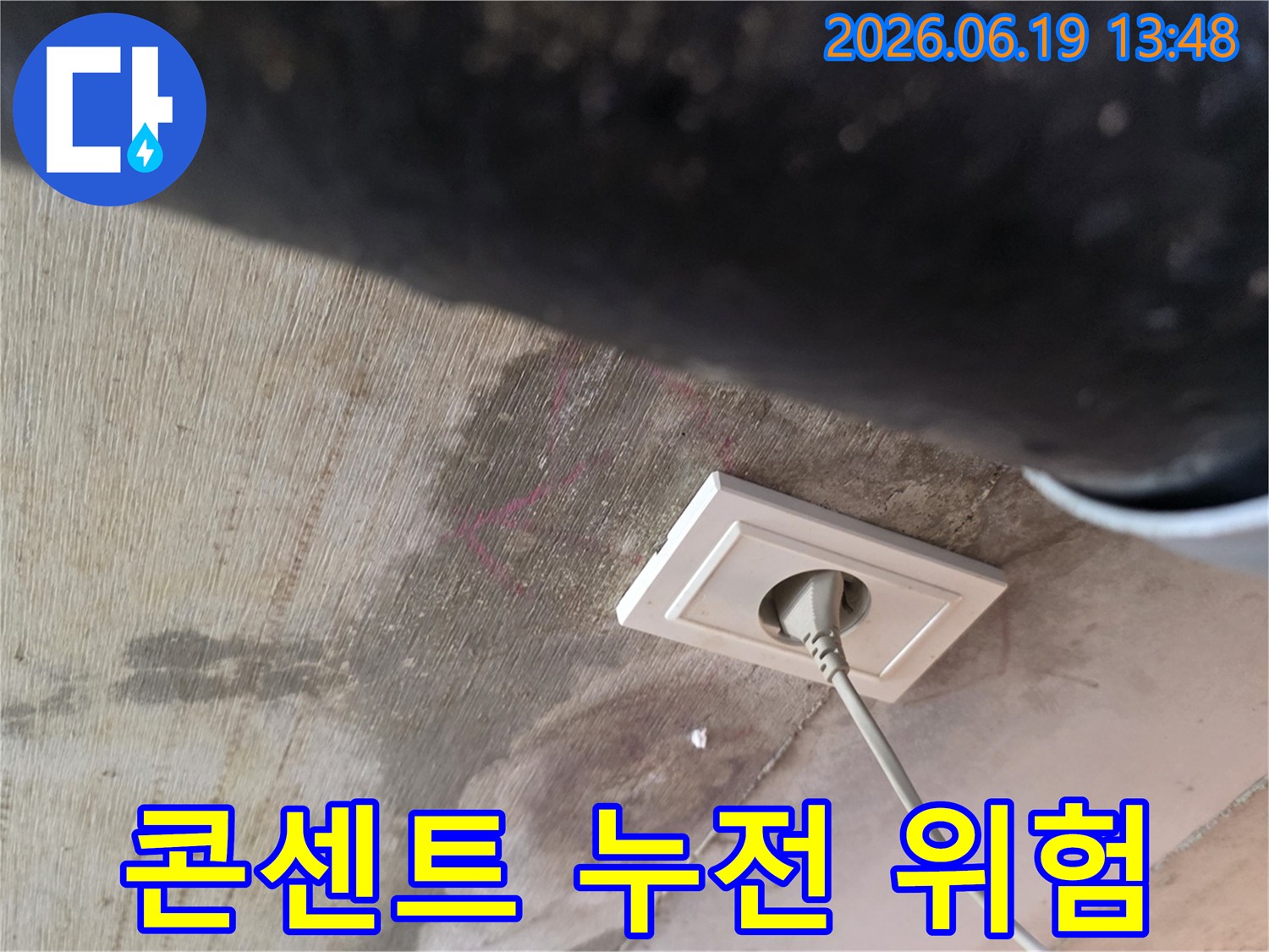 천장 누수로 인해 콘센트 주변에 물기가 스며들어-전기 누전 위험이 있는 상황을 보여주는 현장 사진입니다