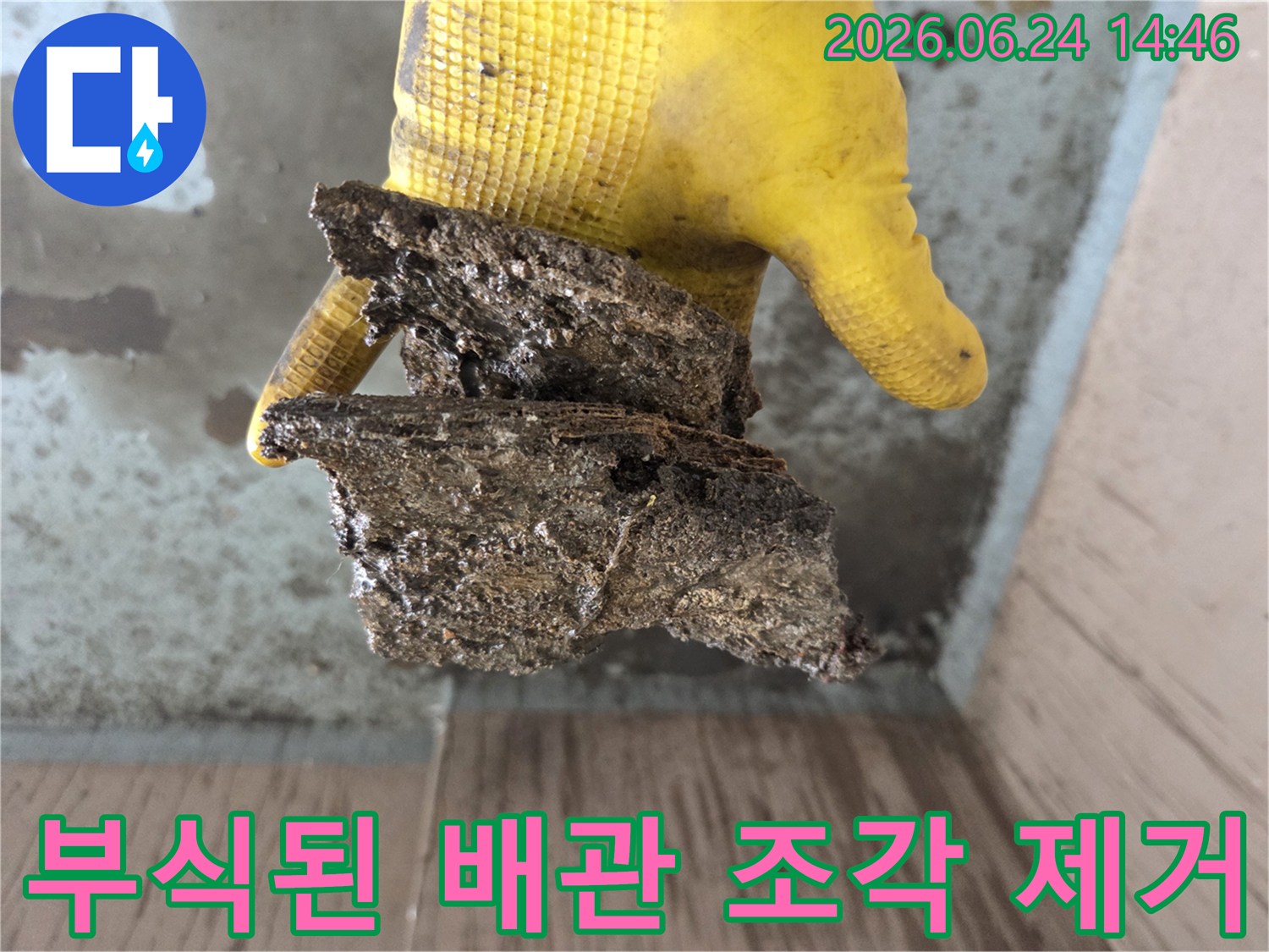 노란색-장갑을-낀-손이-오래된-배관에서-나온-부식된-이물질을-들고-있는-모습입니다-누수-원인-파악을-위한-중요한-단서입니다.