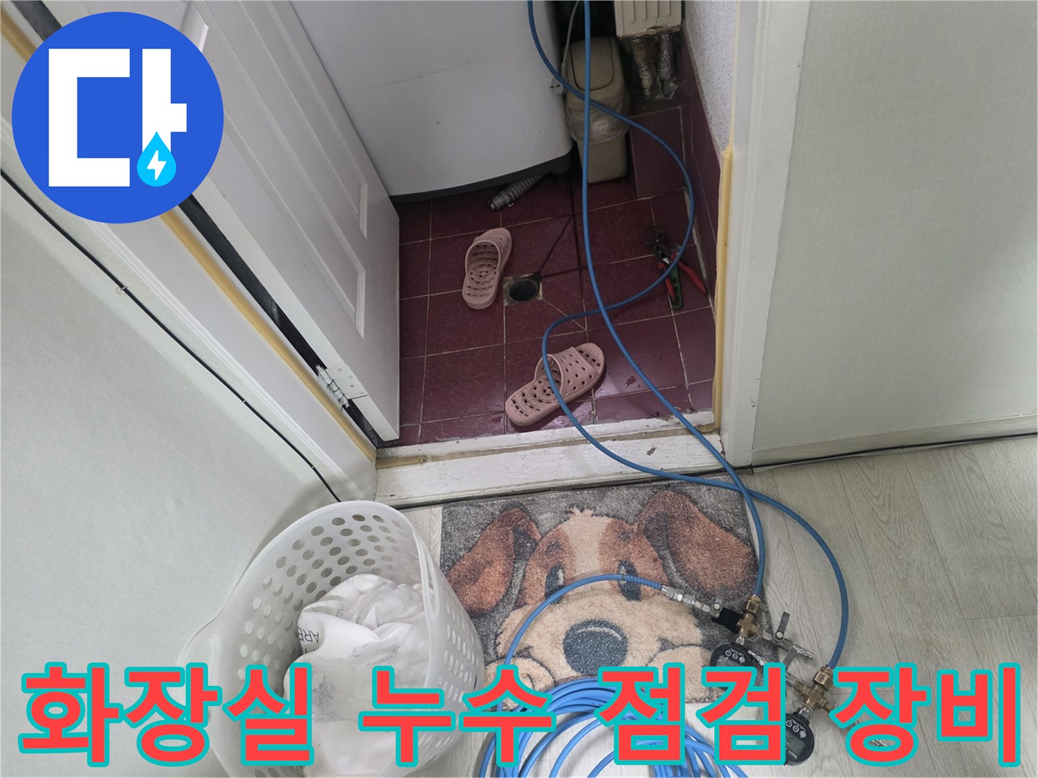 누수 진단을 위해 화장실 입구에 설치된 공압 테스트용 호스와 압력 게이지