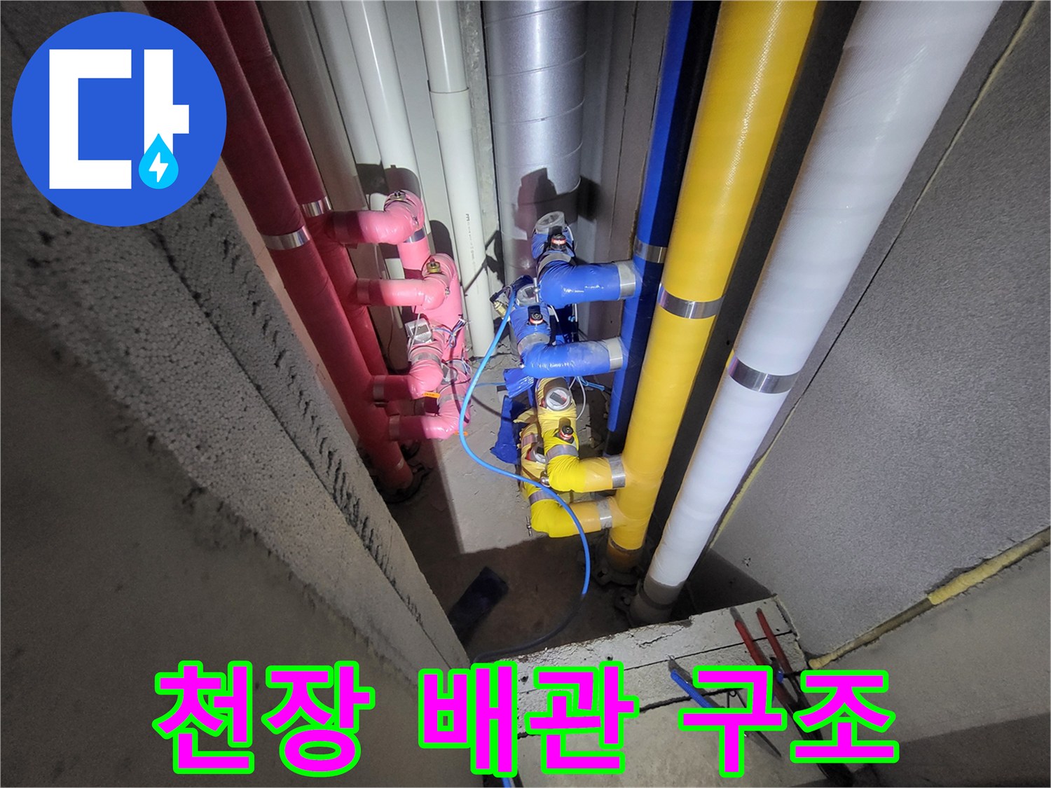 천장 내부에 설치된 다채로운 색상의 급수 및 배수 배관들