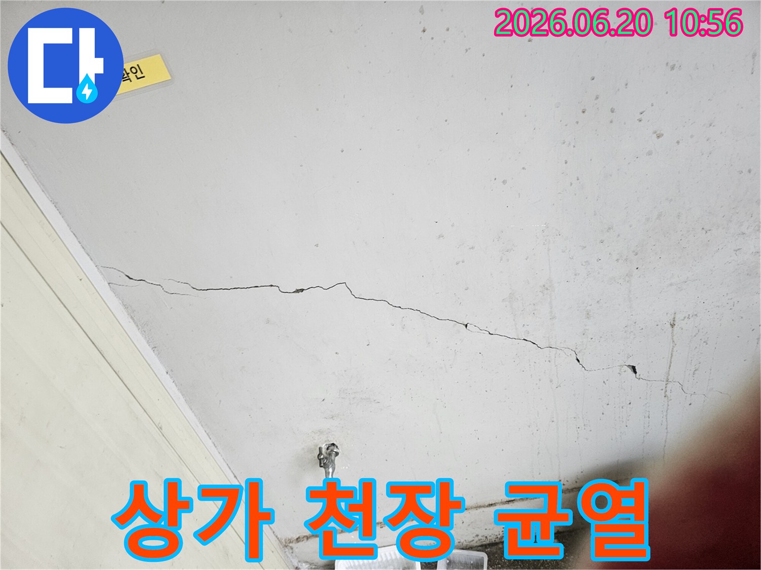 상가 건물 천장에 발생한-구조적 균열과-누수 흔적을-면밀히 조사하는 장면입니다