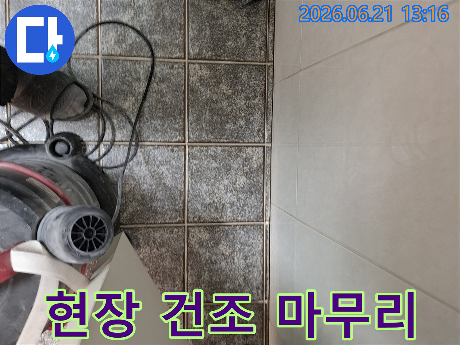 누수 공사 완료 후-타일 바닥에 남은 물기를-습식 청소기로 흡입하여-완벽하게 건조하는 모습