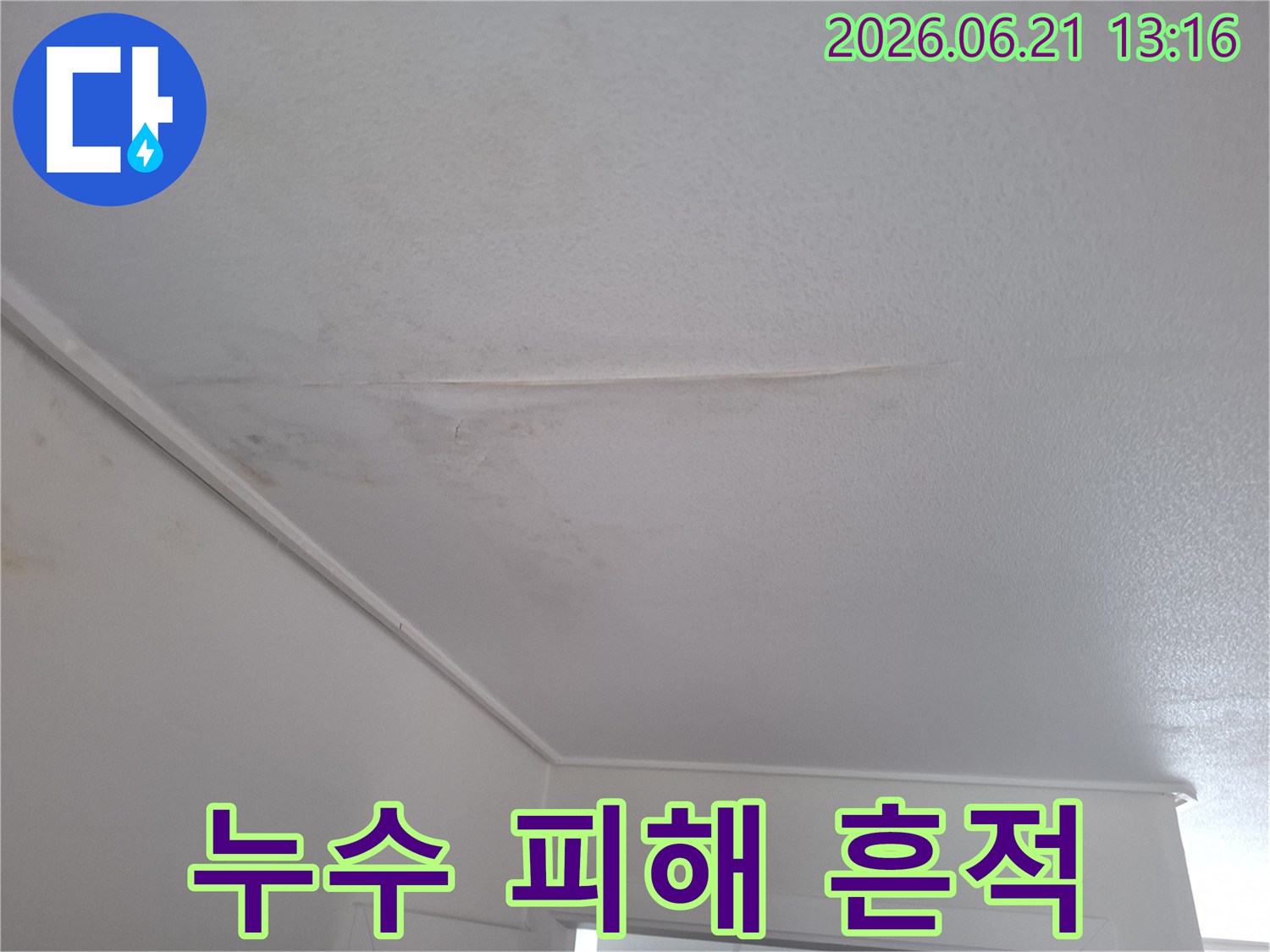 천장-벽지에-길게-이어지는-누수-얼룩과-주변에-번진-물-자국을-보여주는-이미지