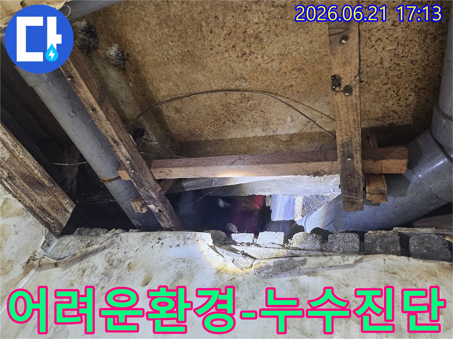 전문가가-어둡고-좁은-공간에서-누수-원인을-찾아-배관을-점검하는-전문가의-모습입니다
