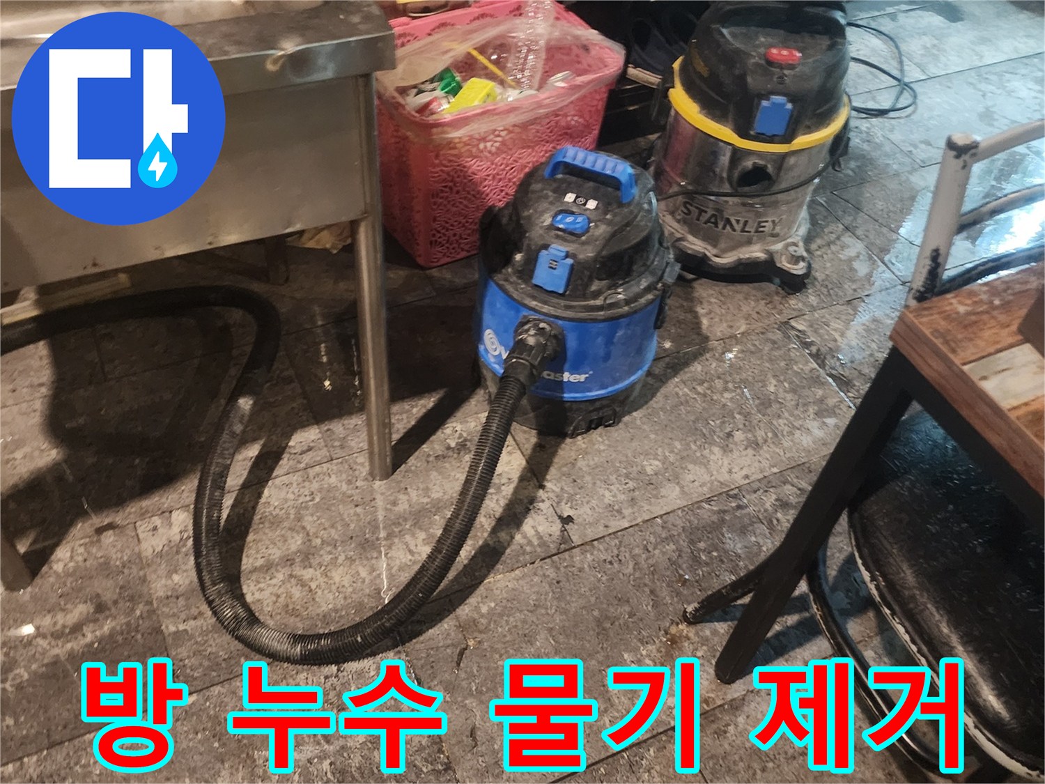 방 누수 현장에서-바닥에 고인 물을-신속하게 흡입하고-습기를 제거하기 위해-사용되는-산업용 석션 장비 두 대가-바닥에 놓여있는 모습입니다.