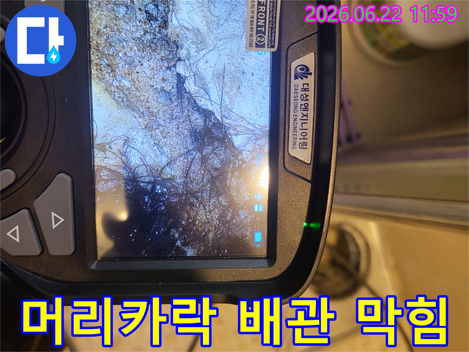 누수 탐지 전문가가-배관 내시경으로 오수관 내부를 촬영하여-머리카락과 슬러지로 막힌 상태를 확인하는 모습