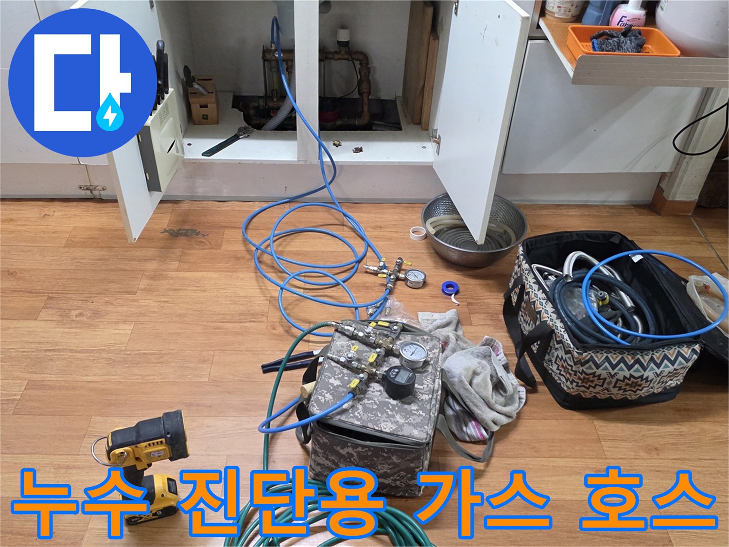 싱크대 아래 배관에 연결된 파란색 공압 테스트용 튜브와 측정기