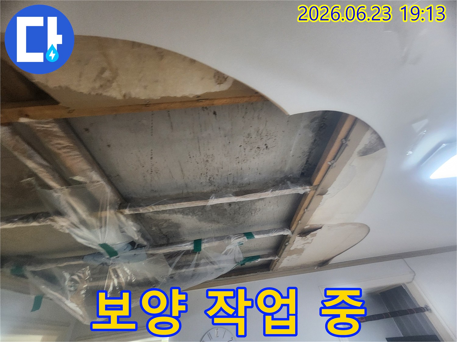 윗집 누수로 인해-콘크리트 슬라브가 젖어있고-배관 주변에 비닐 보양을 한 상태를 보여줍니다
