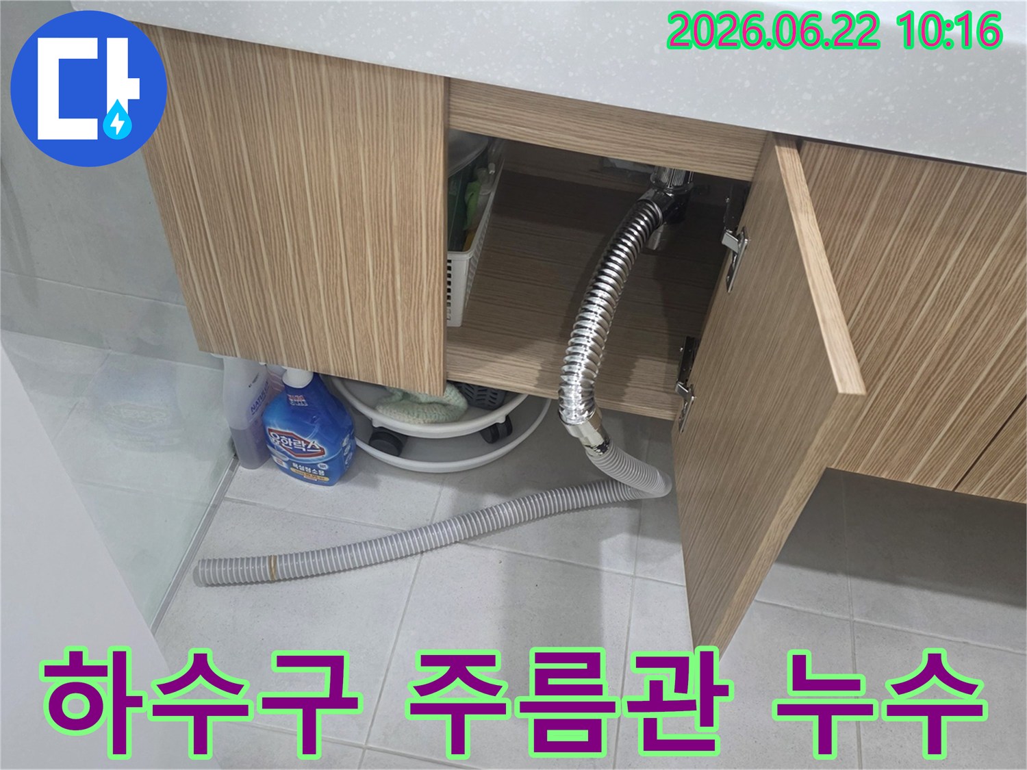 세면대 하부장 아래에서 배수 주름관이 빠져나와 물이 새고 있는-누수 현장의 사진