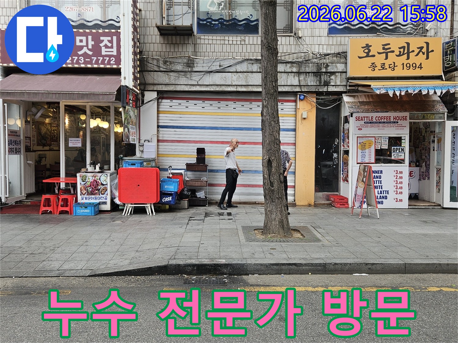서울-종로구-수표로-지역의-상가-건물-앞에-누수-전문가가-방문하여-건물-외관을-살피며-누수-상황을-파악하는-모습입니다.