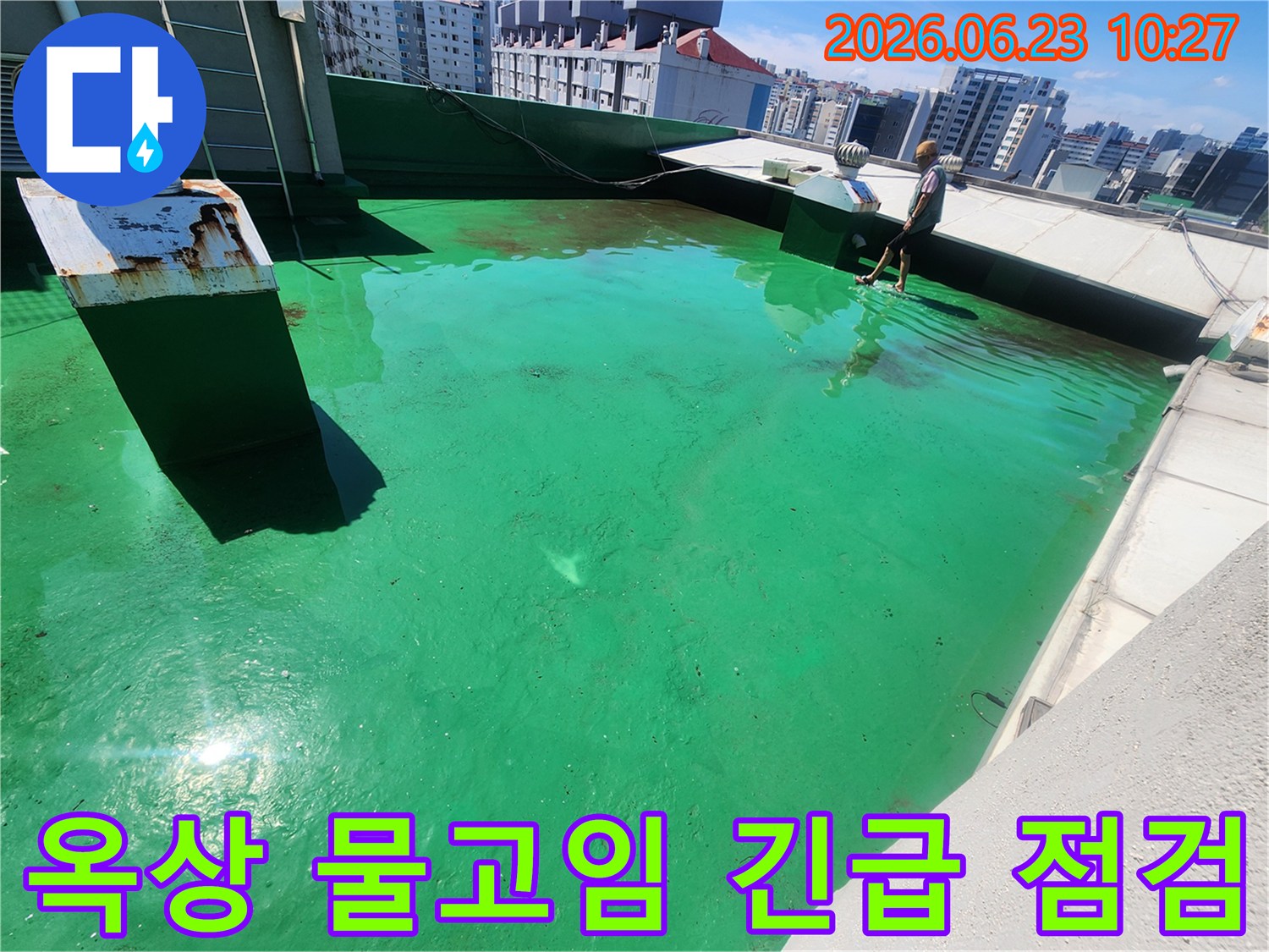 이 이미지는-송파구 옥상에서-누수 발생 가능성이 있는-물고임 현상을-전문가가 긴급 점검하는 모습입니다.
