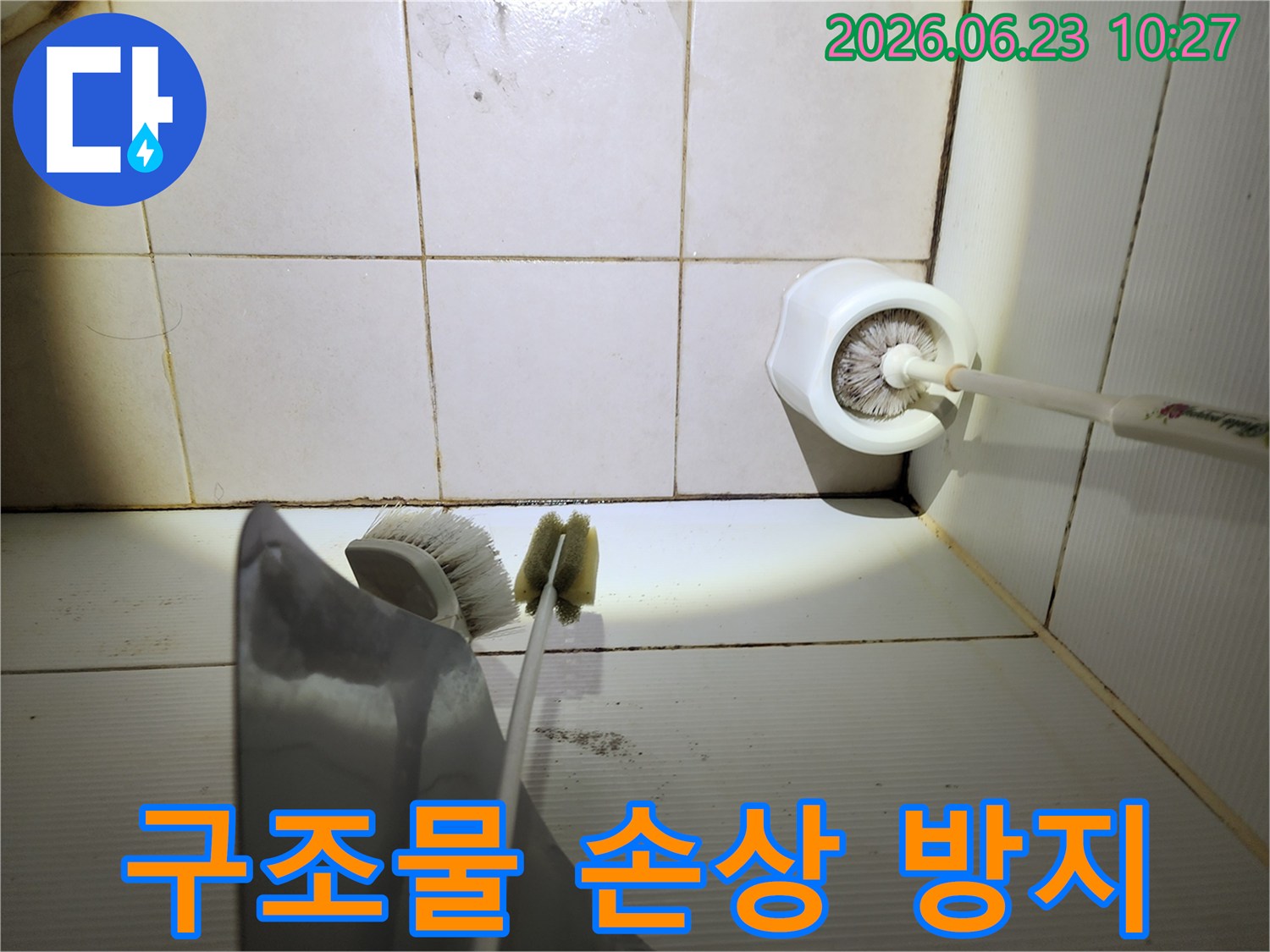 이 이미지는-욕실 바닥 타일의-줄눈에 생긴-검은 곰팡이와-오염된 청소용품-주변을-보여주며-구조물 손상 방지의-중요성을-시사합니다.