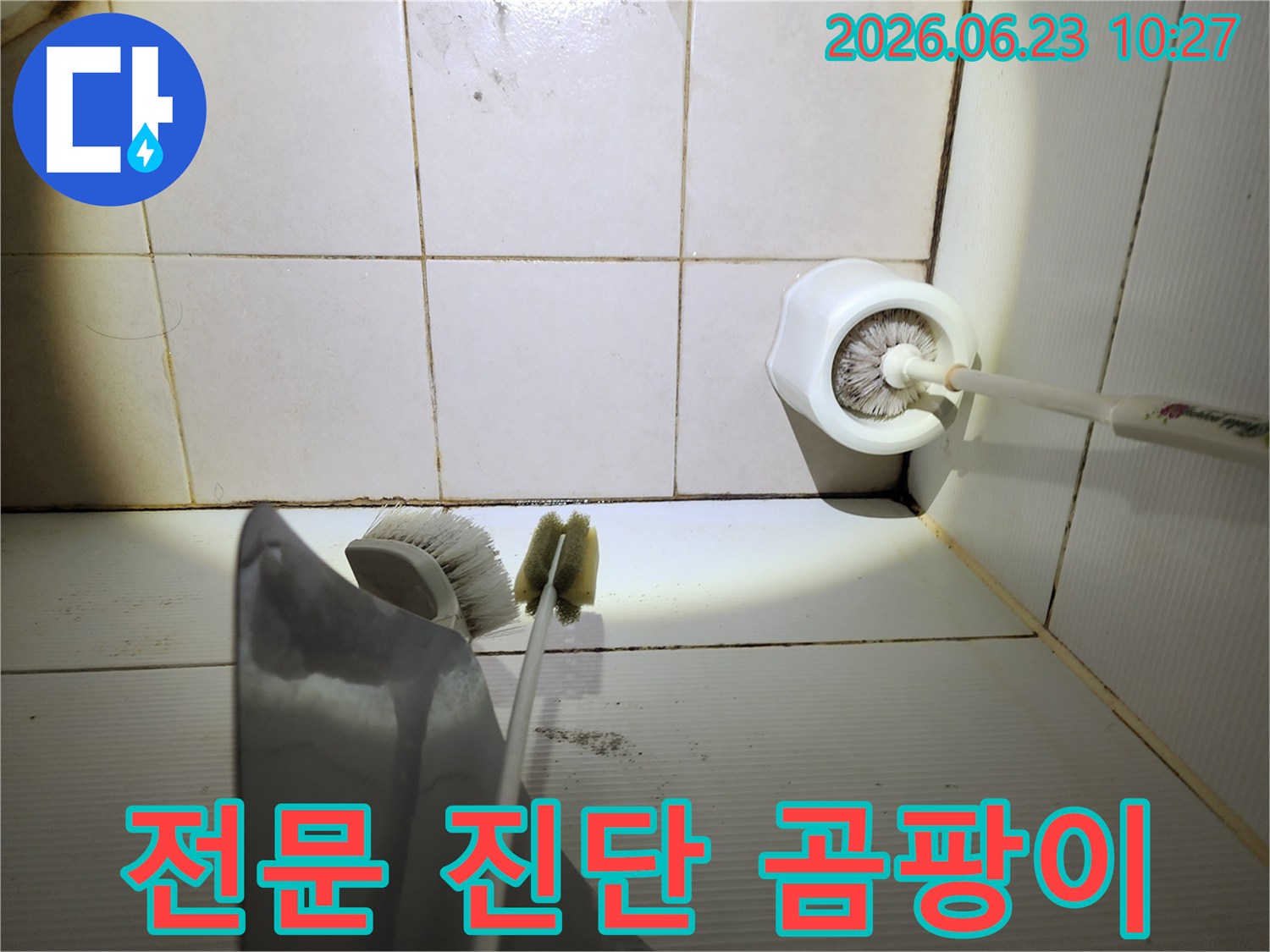 이 이미지는-욕실 바닥 타일의-줄눈에 생긴-검은 곰팡이와-오염된 청소용품-주변을-보여주며-전문적인 누수 진단의-필요성을-시사합니다.