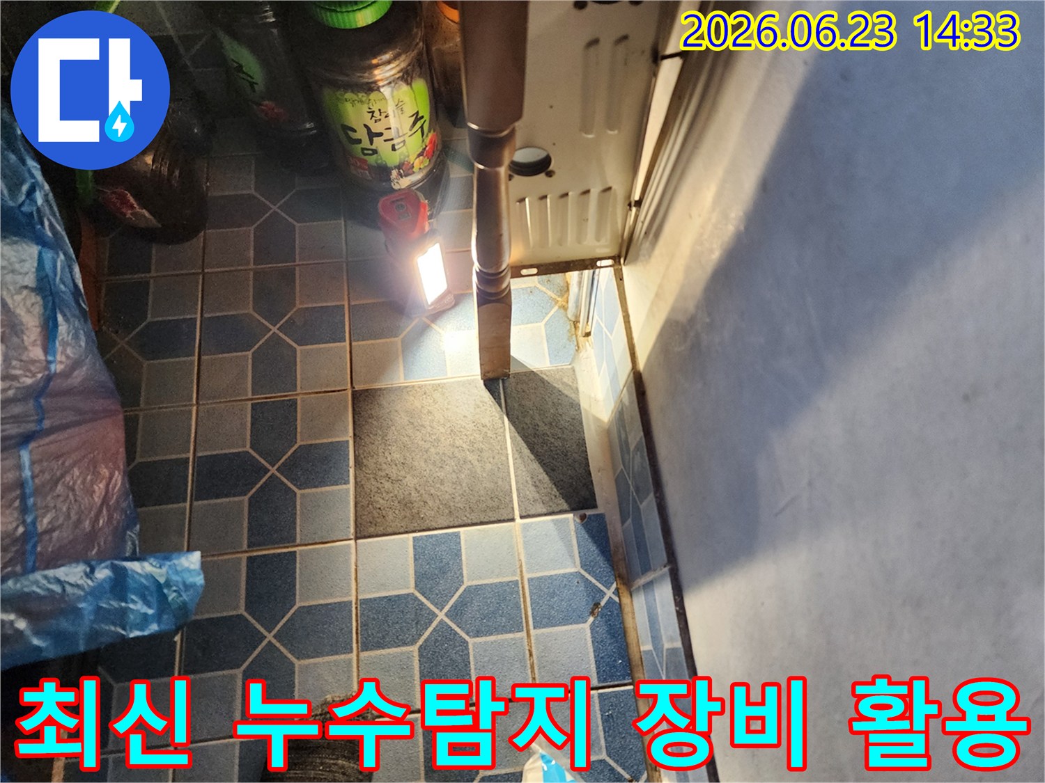 강북구-월계동-현장에서-누수-전문가가-최신-누수탐지-장비를-활용하여-바닥-타일-아래의-누수-지점을-정확하게-진단하는-모습입니다.