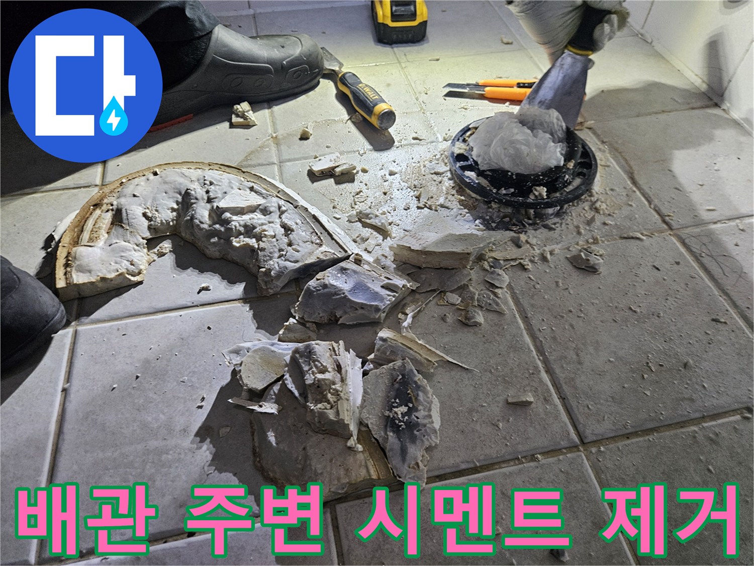 변기 하단 배관 노출을 위해 타일을 깨뜨려 놓은 현장 사진입니다.