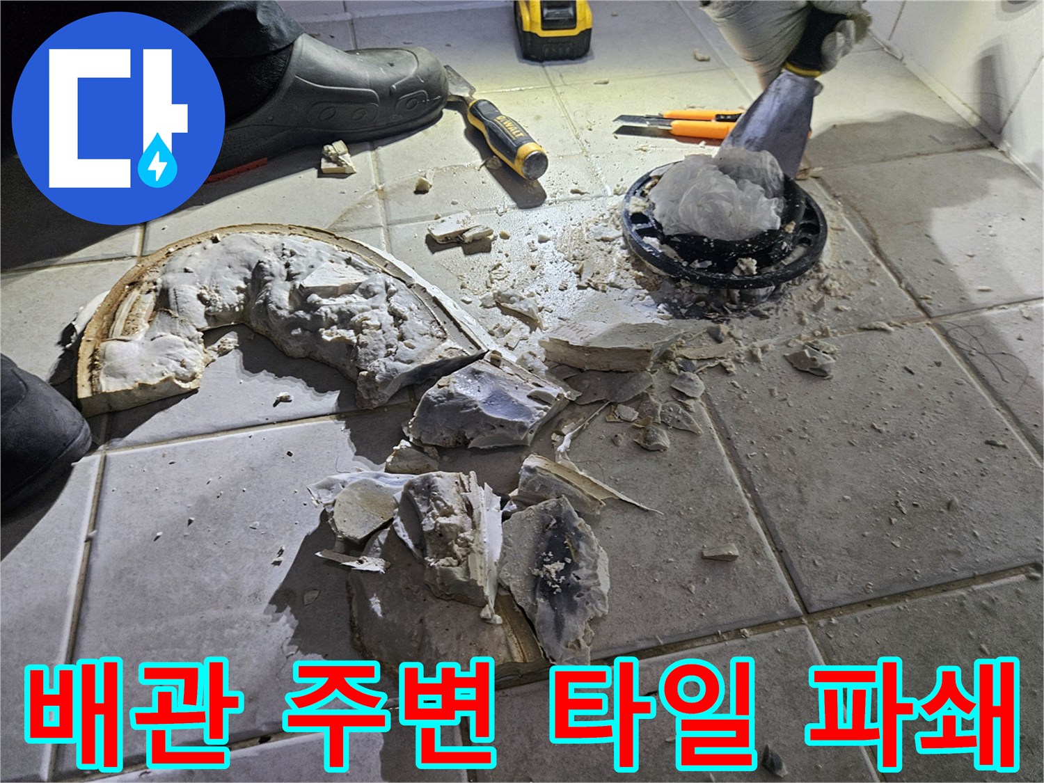 변기 하단 배관 부근의 젖은 타일과 깨진 자재들입니다.