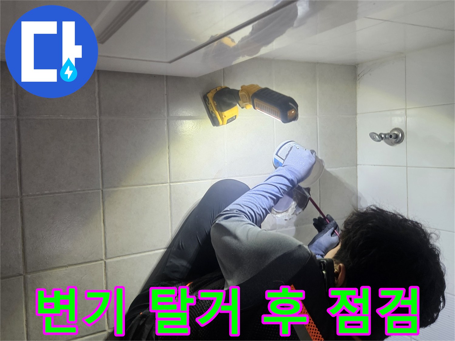 탈거된 변기 주변 배관 부위를 랜턴으로 비추며 조사하는 모습입니다.