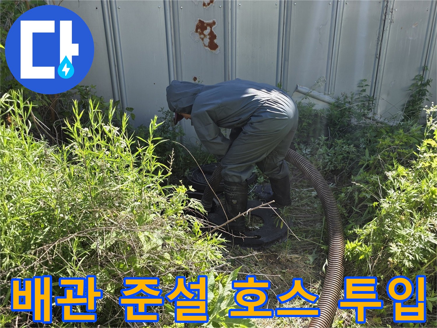 지면의 맨홀 부근에서 배관 청소를 위해 호스를 조작하는 엔지니어