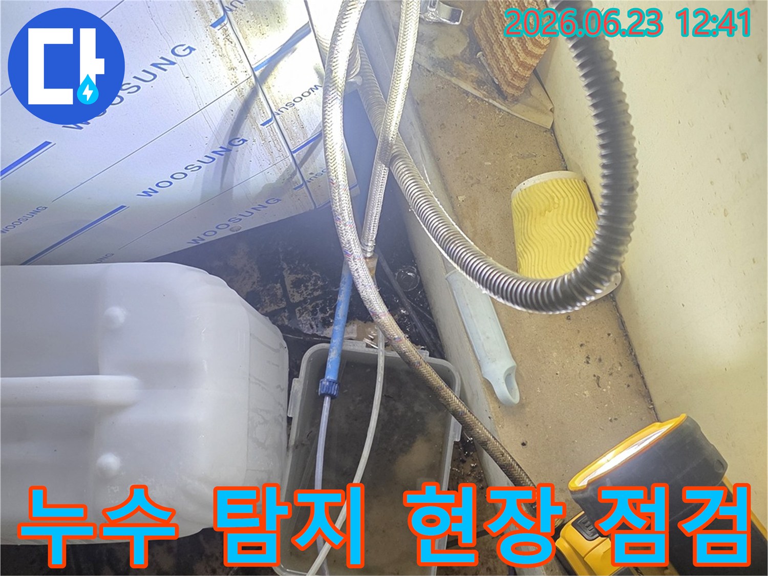 마포구 망원동 아파트에서-누수 엔지니어가-고성능 조명으로-배관 주변을-정밀하게 점검하며-누수 원인을-찾는 모습입니다.